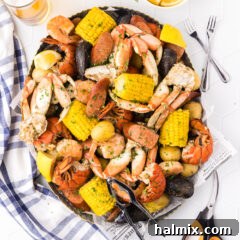 Ocean's Harvest Feast 12 Seafood Boil in a metal serving platter with seafood utensils on the side