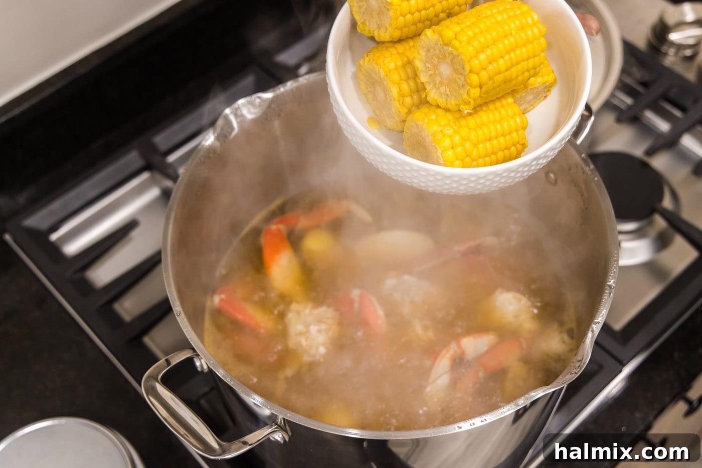 Ocean's Harvest Feast 7 adding corn to pot of water with crab legs