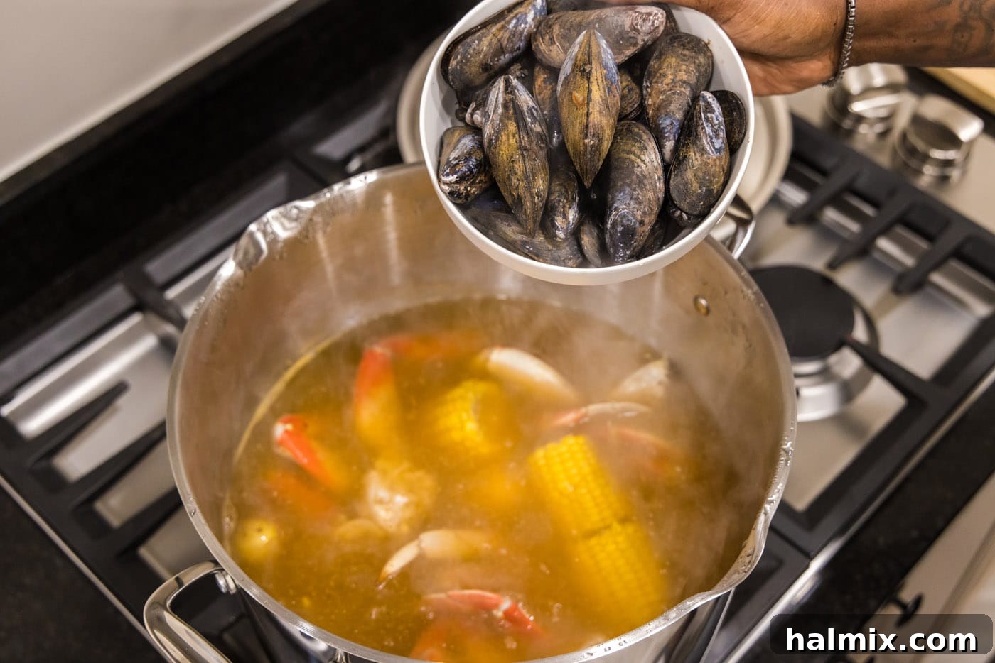 Ocean's Harvest Feast 8 adding mussels to pot with seafood boil