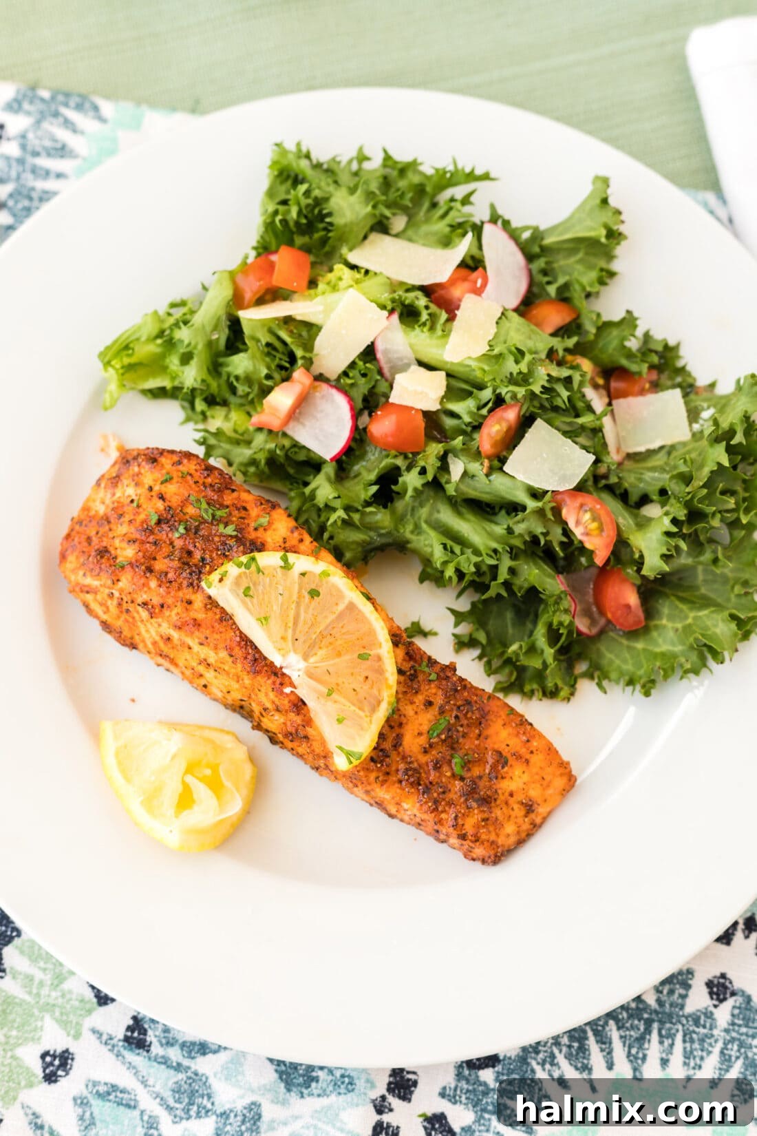 Air Fryer Salmon on a plate with a side salad