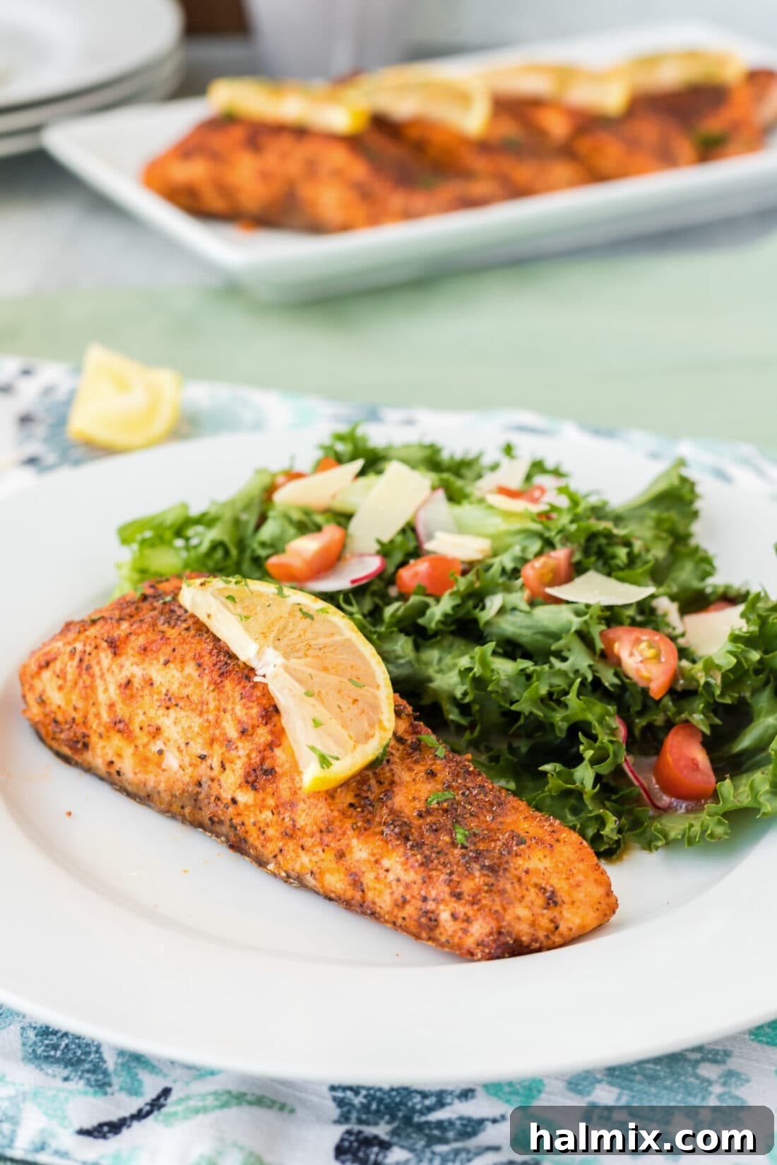 Air Fryer Salmon on a plate with a slice of lemon on top