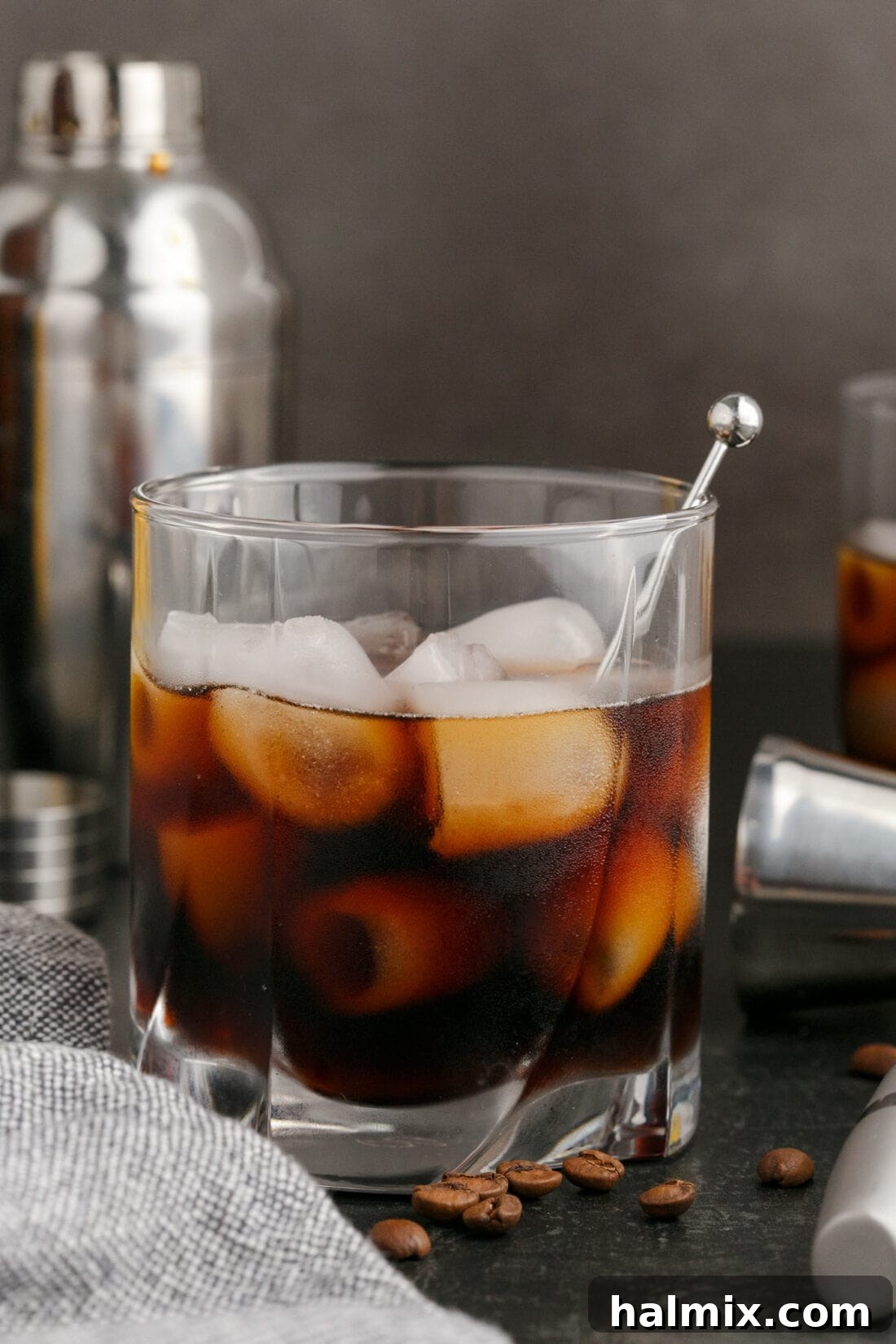 Black Russian with a cocktail shaker in the background, hinting at fresh preparation