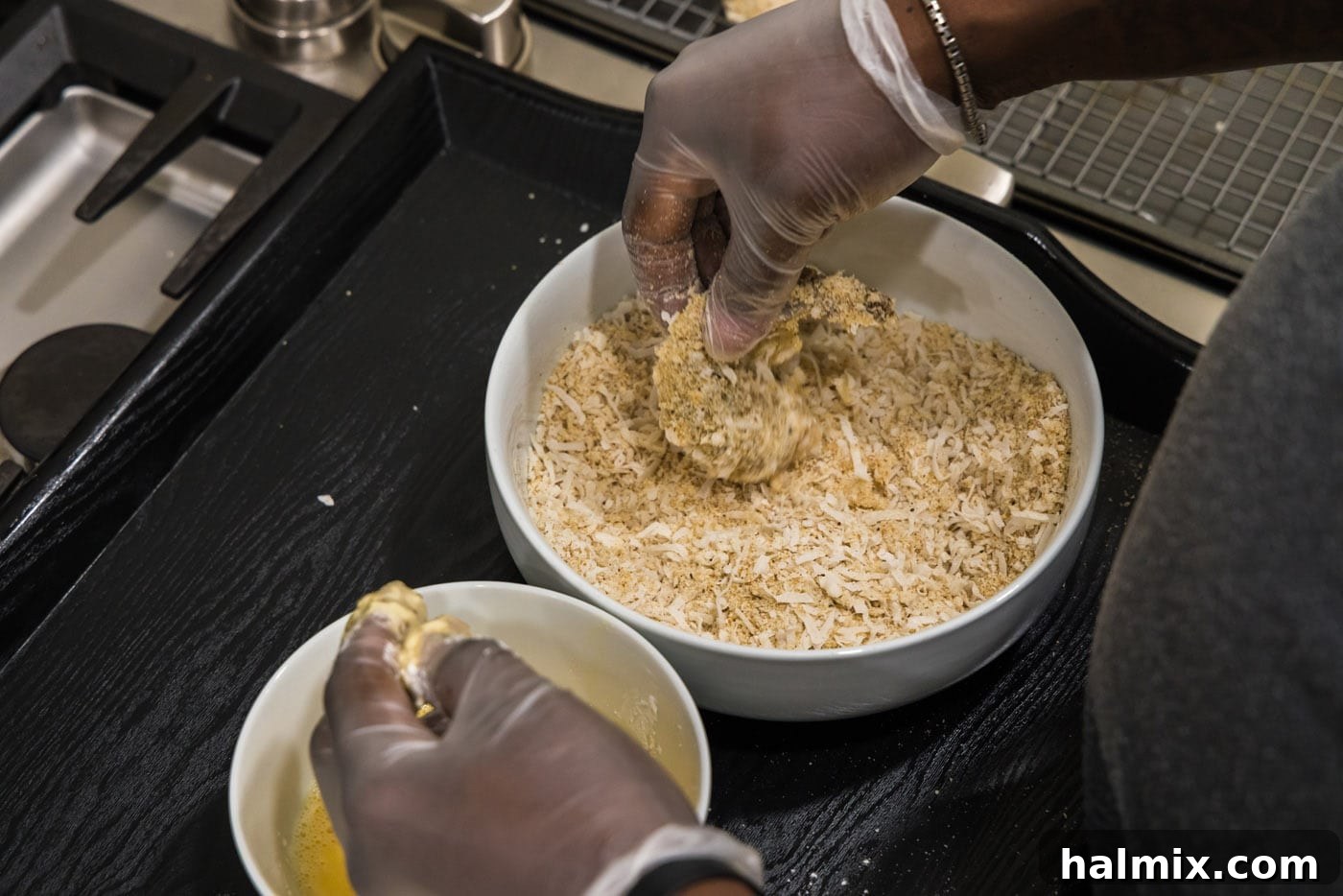 Close-up of shrimp being thoroughly coated in the panko and coconut mixture