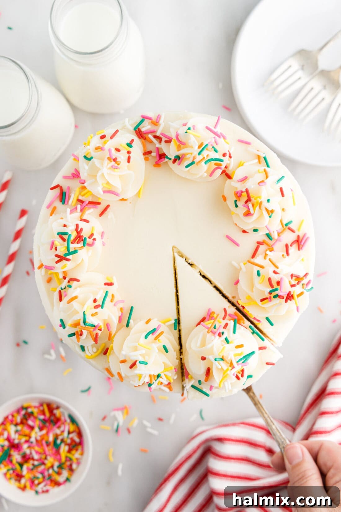 Festive Sprinkle Cake 2 Overhead photo of Funfetti Cake with a slice being removed