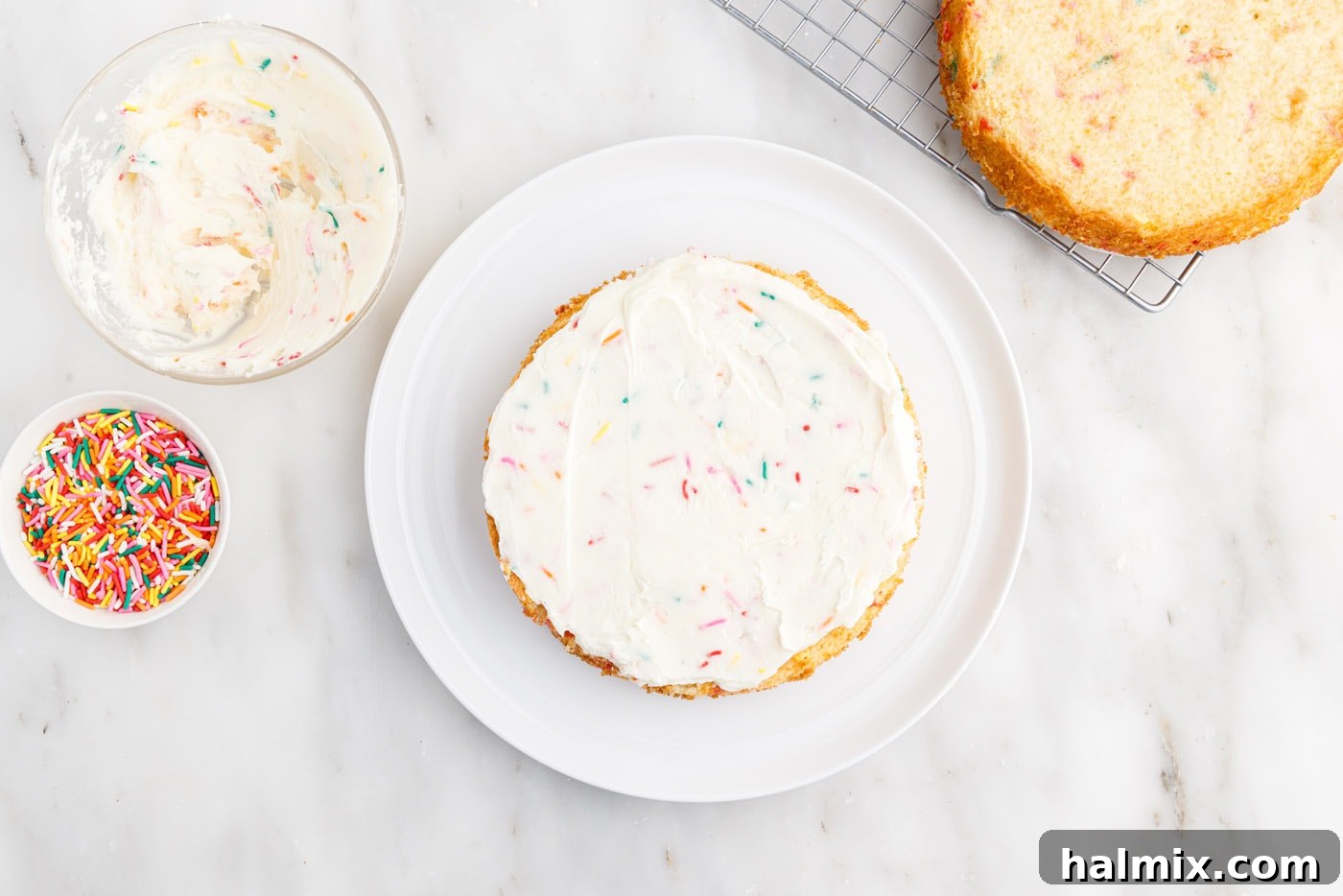 Festive Sprinkle Cake 18 frosting on top of cake layer