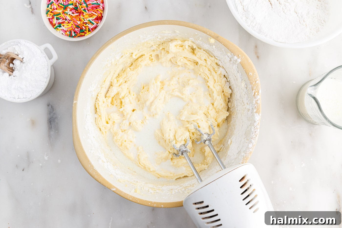 Festive Sprinkle Cake 9 adding milk to cake batter in a bowl