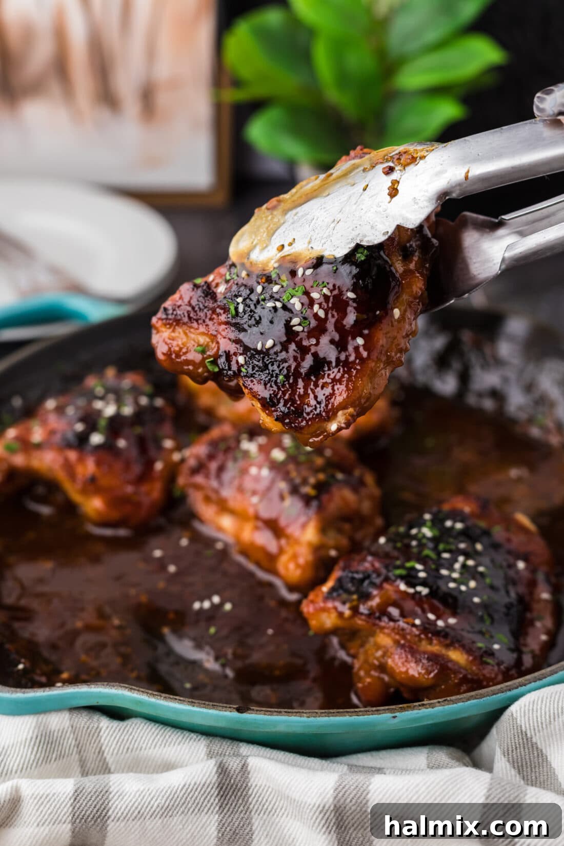 Piece of Honey Garlic Chicken being lifted out of the skillet