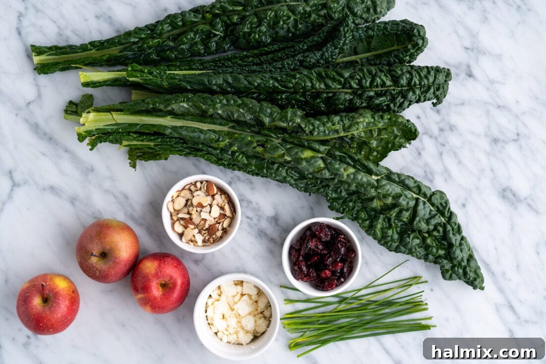 A selection of fresh ingredients including kale, apples, craisins, and feta