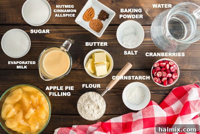 Ingredients for Apple Cranberry Crisp laid out on a table, including canned apple pie filling, cranberries, flour, sugar, butter, and spices.