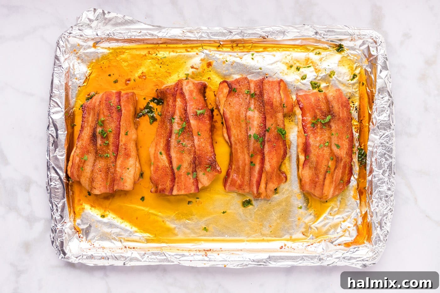 Crispy Bacon Chicken Bundles 10 finished bacon wrapped chicken on a baking sheet, ready to serve