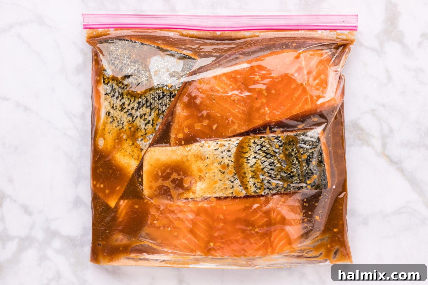 Salmon fillets marinating in a zip-top bag with teriyaki sauce