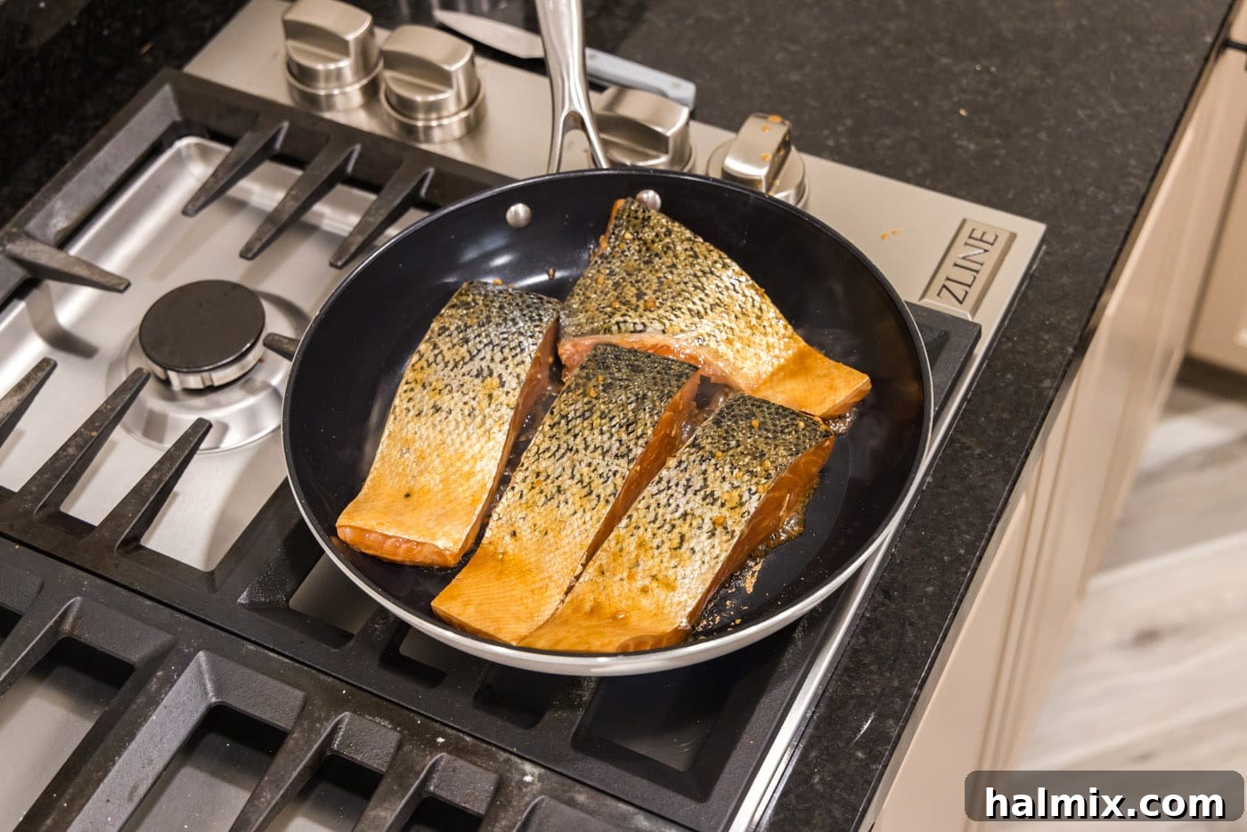 Salmon fillets pan-searing in a hot skillet
