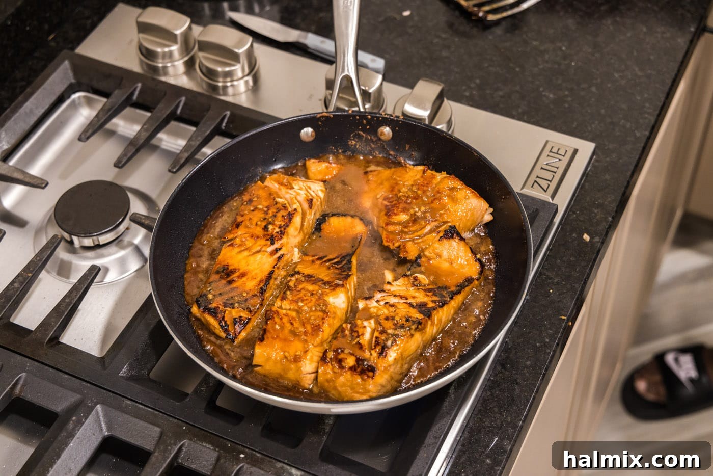 Cooked teriyaki salmon in a skillet, glistening with glaze