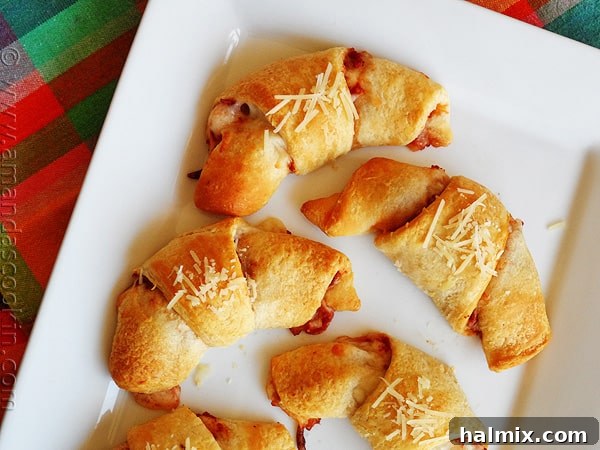 Cheesy Pizza Crescent Pinwheels 3 An overhead close up photo of pizza crescent roll ups on a white platter.