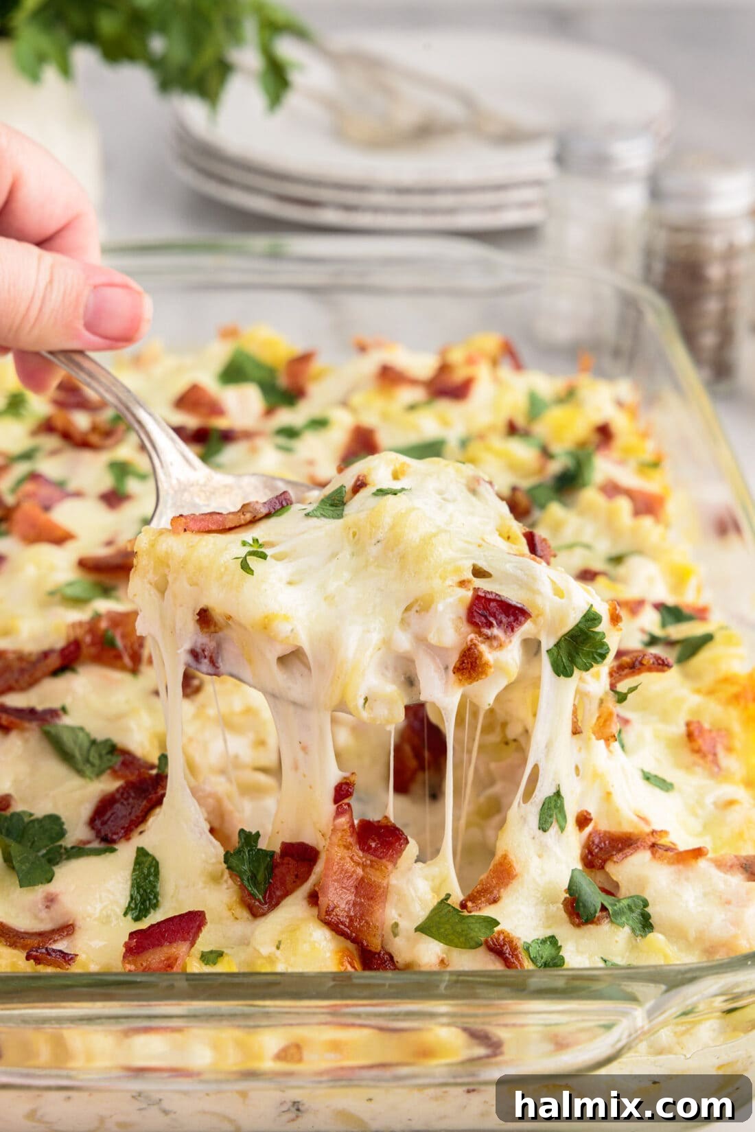 Spoonful of Creamy Chicken Bacon Ranch Casserole being lifted out of the casserole dish