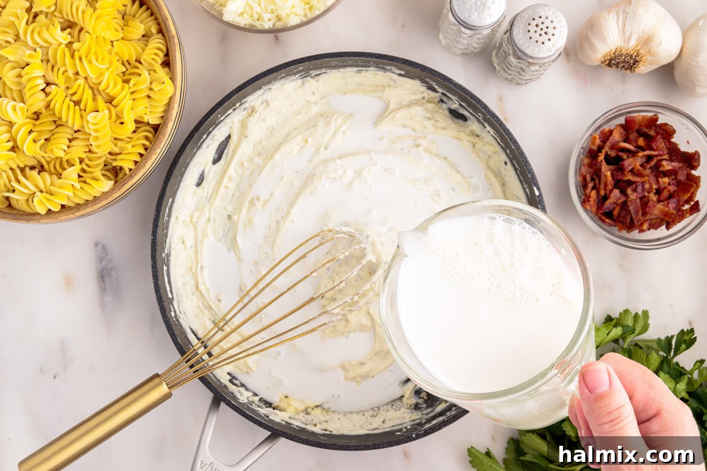 pouring whole milk into skillet with cream cheese