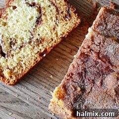 A close-up photo of a beautifully sliced loaf of cinnamon raisin swirl quick bread on a wooden cutting board, ready to be enjoyed.