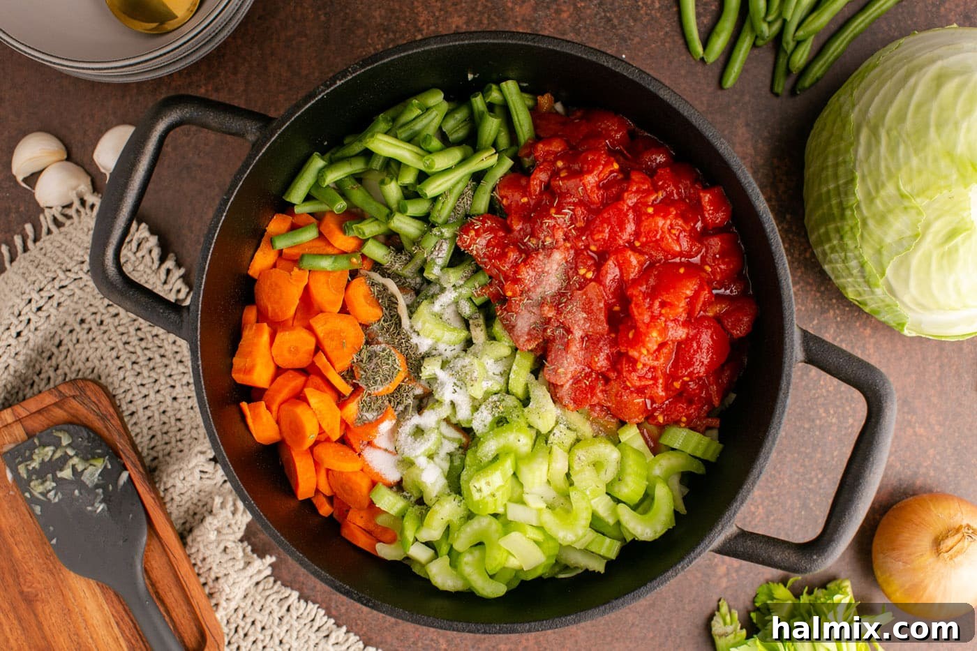 celery, carrot, onion, tomato, and green beans in a soup pot
