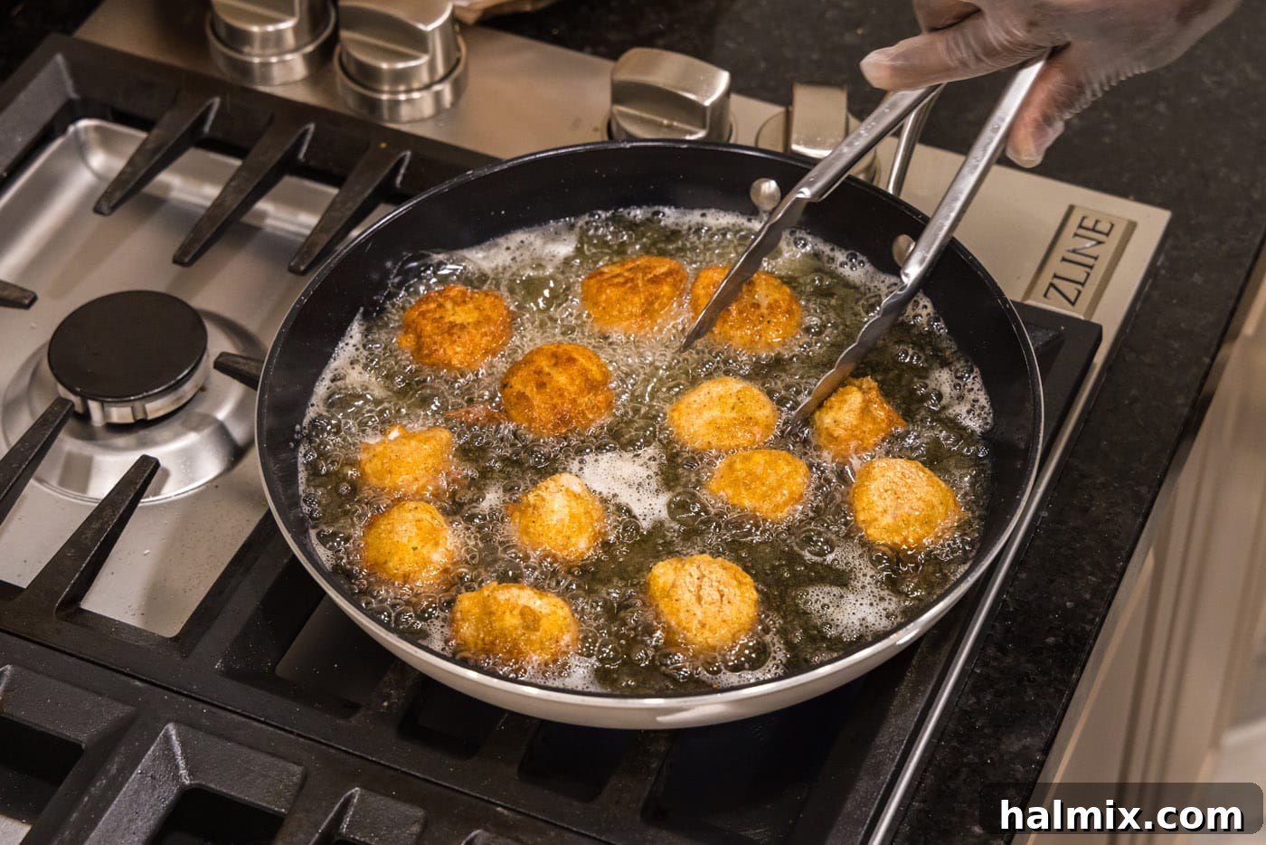 Golden Seared Scallops 13 tongs flipping fried scallops in a skillet