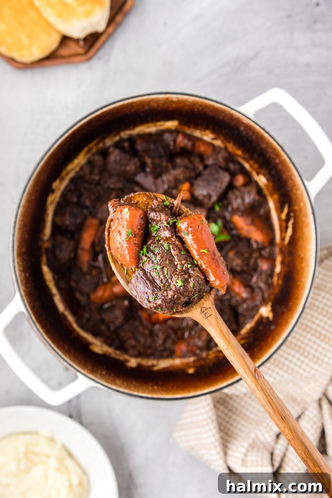 Spoonful of Braised Beef held over a pot of Braised Beef