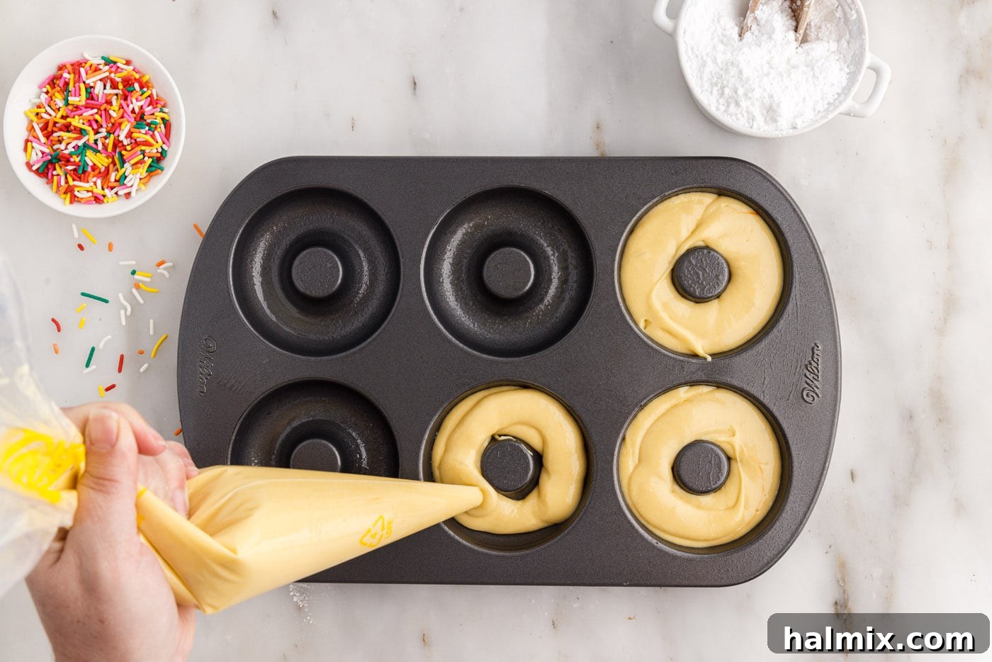 Easy Cake Mix Donuts 7 piping cake mix donut batter into a donut pan
