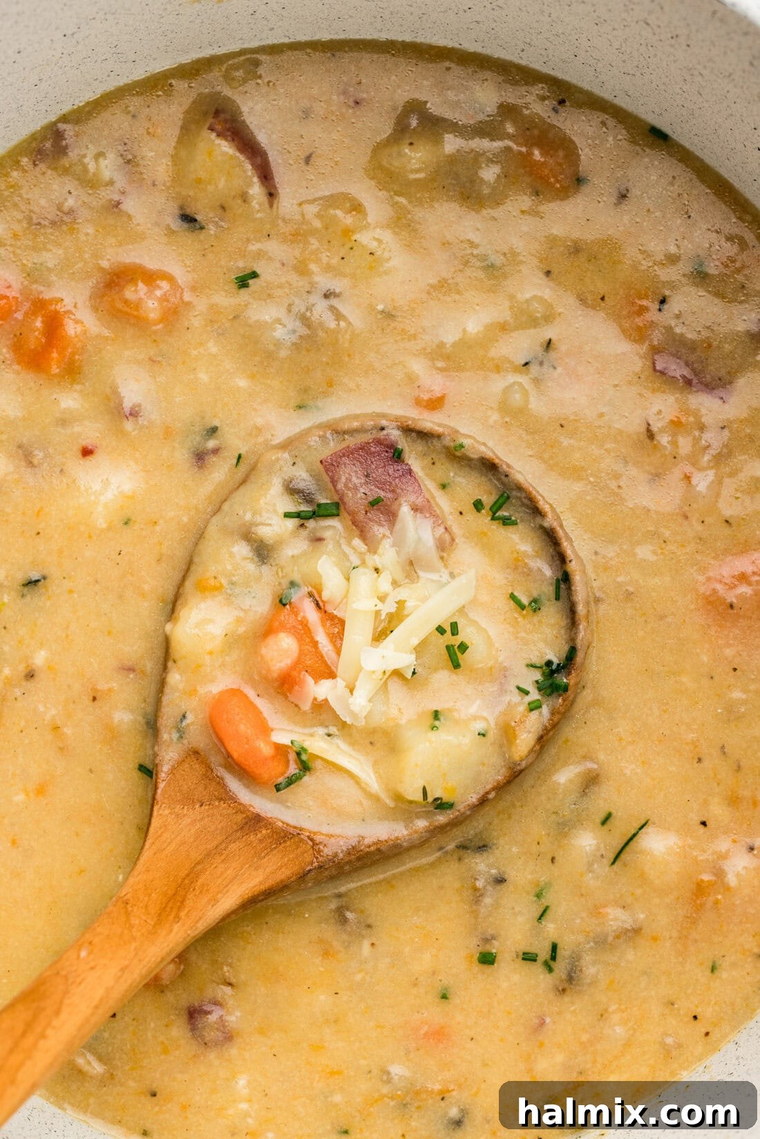 Close up photo of a ladle in a pot of Garlic Potato Soup