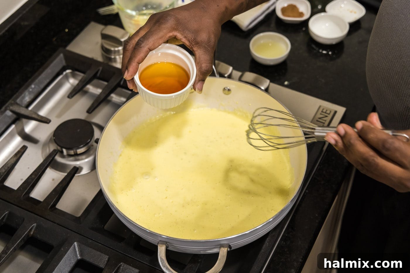 adding cognac to skillet with cream sauce