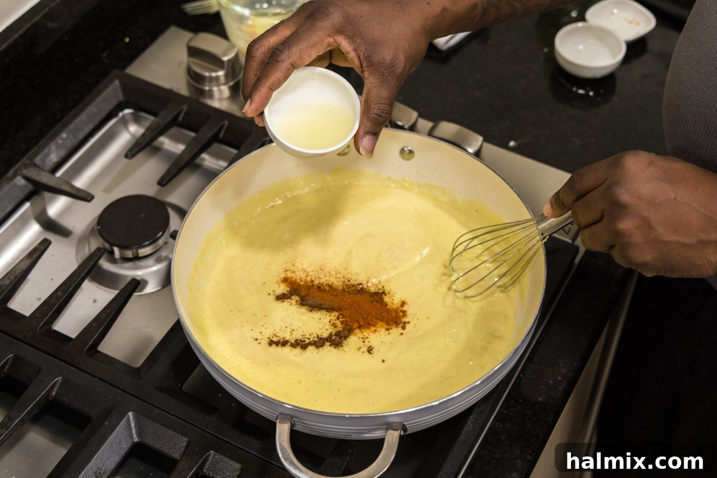 adding lemon juice to cream mixture with seasonings in a skillet