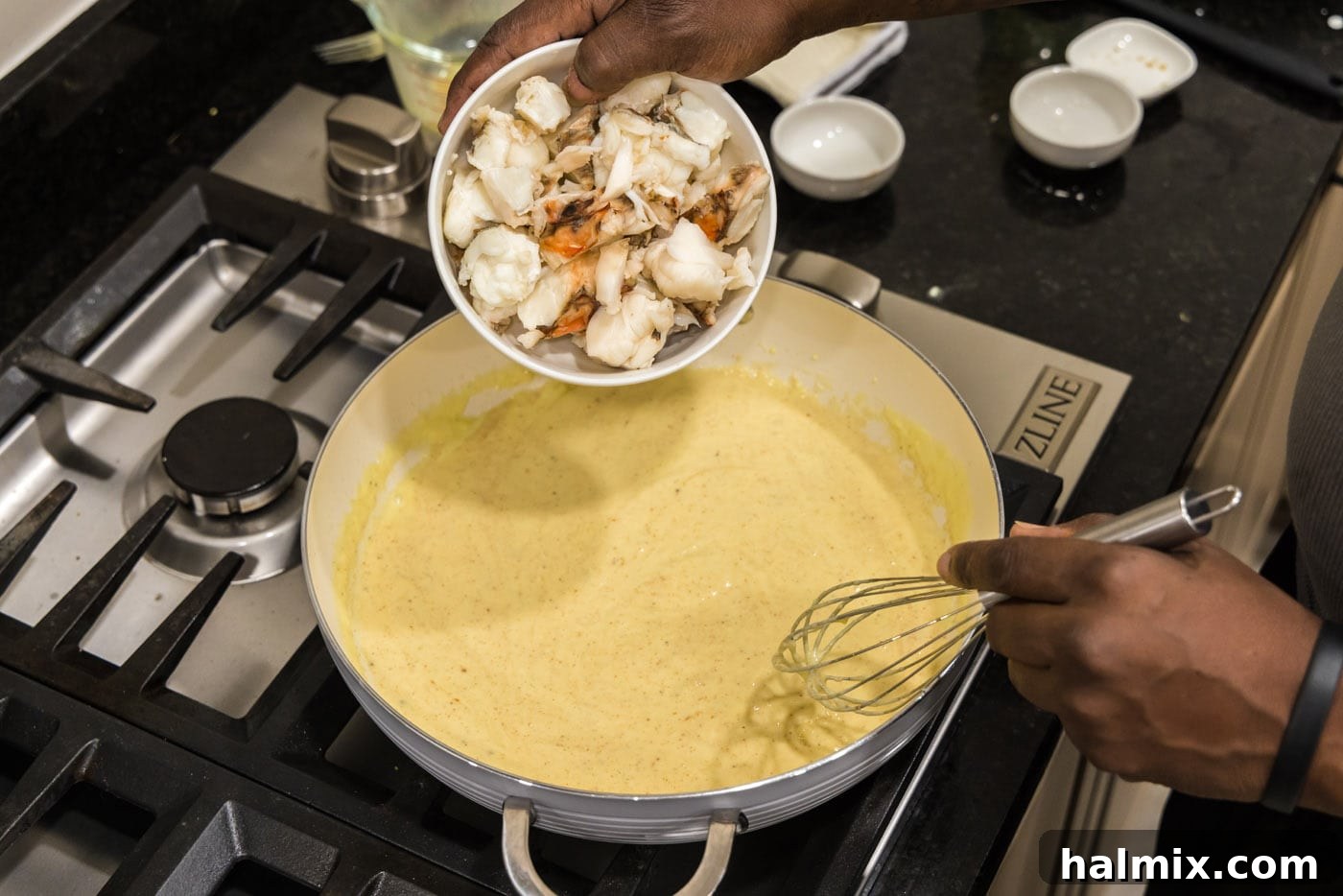 pouring lobster into cream sauce