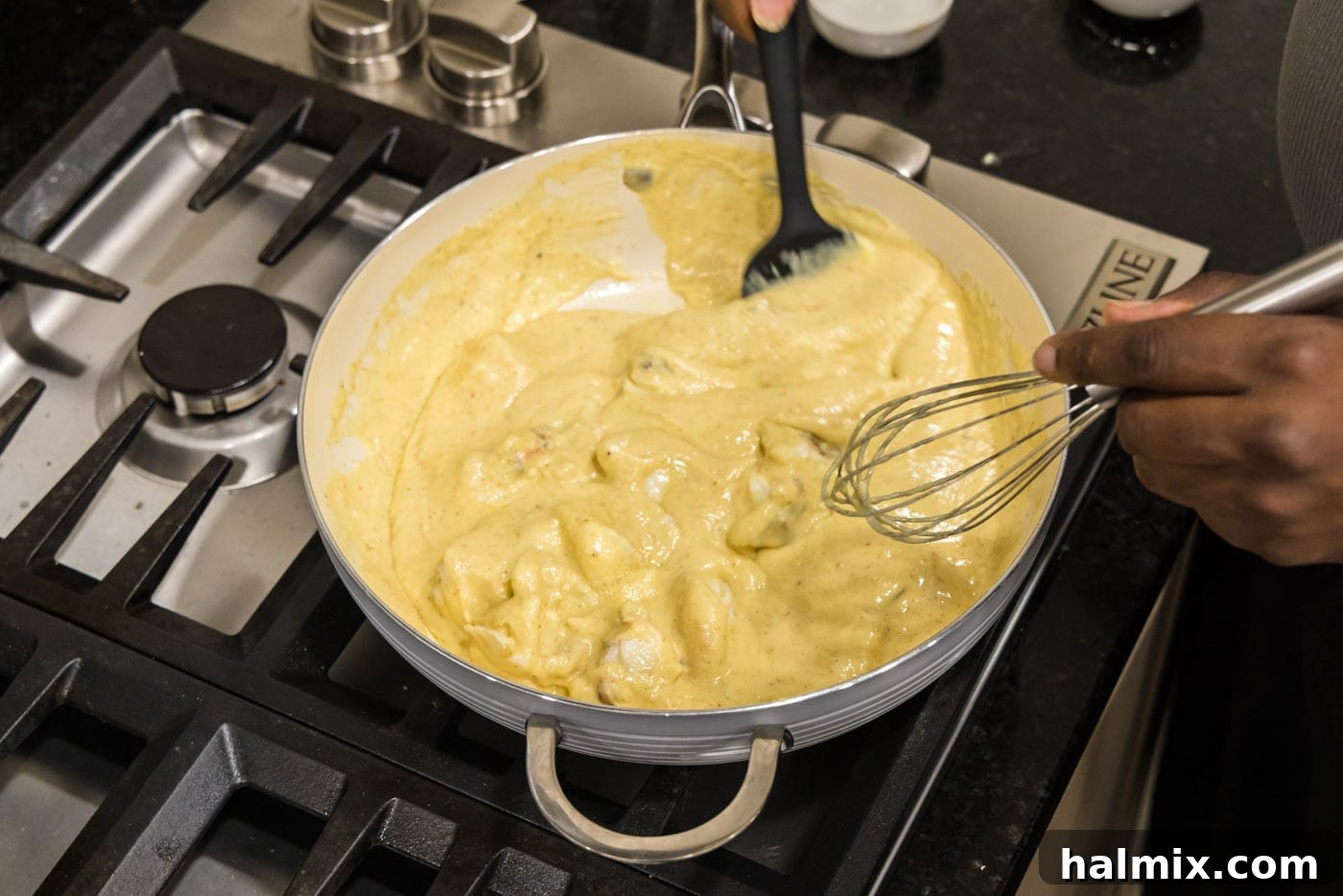 mixing lobster chunks into cream sauce for lobster newburg