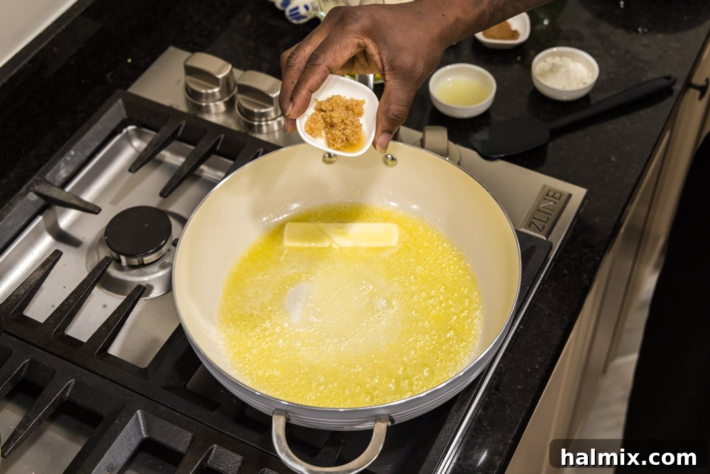 adding minced garlic to butter in a skillet