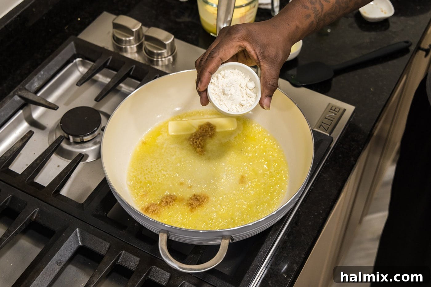 adding flour to skillet with garlic and butter