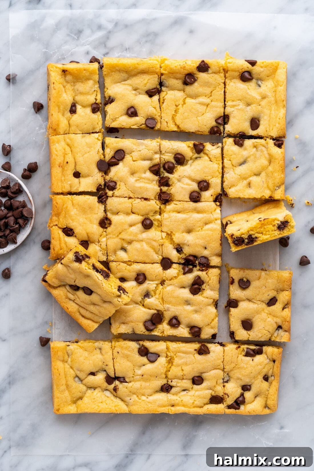Easy Cake Mix Cookie Bars 2 Sheet of freshly baked Cake Mix Cookie Bars cut into squares on parchment paper, ready to serve.