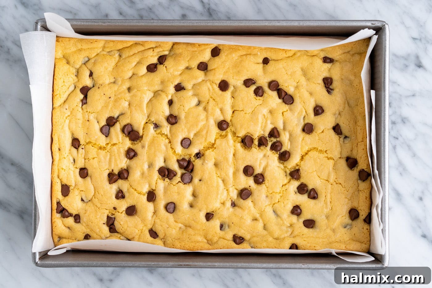 Freshly baked cake mix cookie bars in the pan, showing a light golden brown edge and soft center.