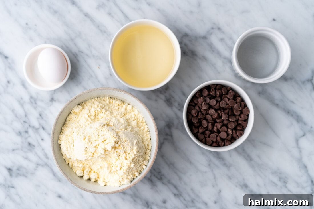 Easy Cake Mix Cookie Bars 4 Collection of raw ingredients for Cake Mix Cookie Bars, including a box of cake mix, chocolate chips, oil, water, and an egg.