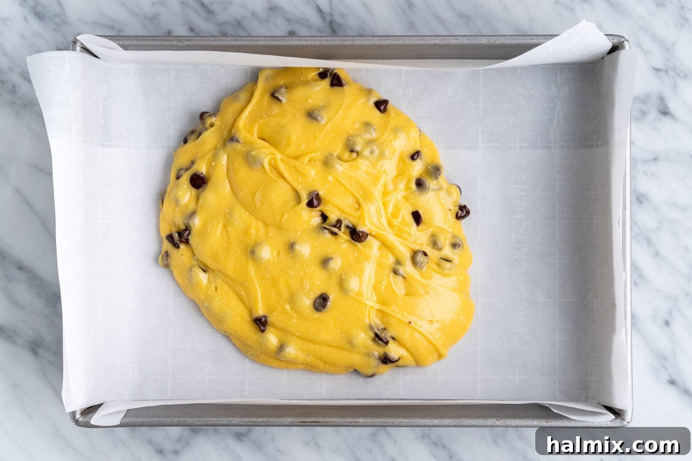 Easy Cake Mix Cookie Bars 9 Cake mix cookie bar batter being carefully poured into the prepared 9x13 inch baking dish.
