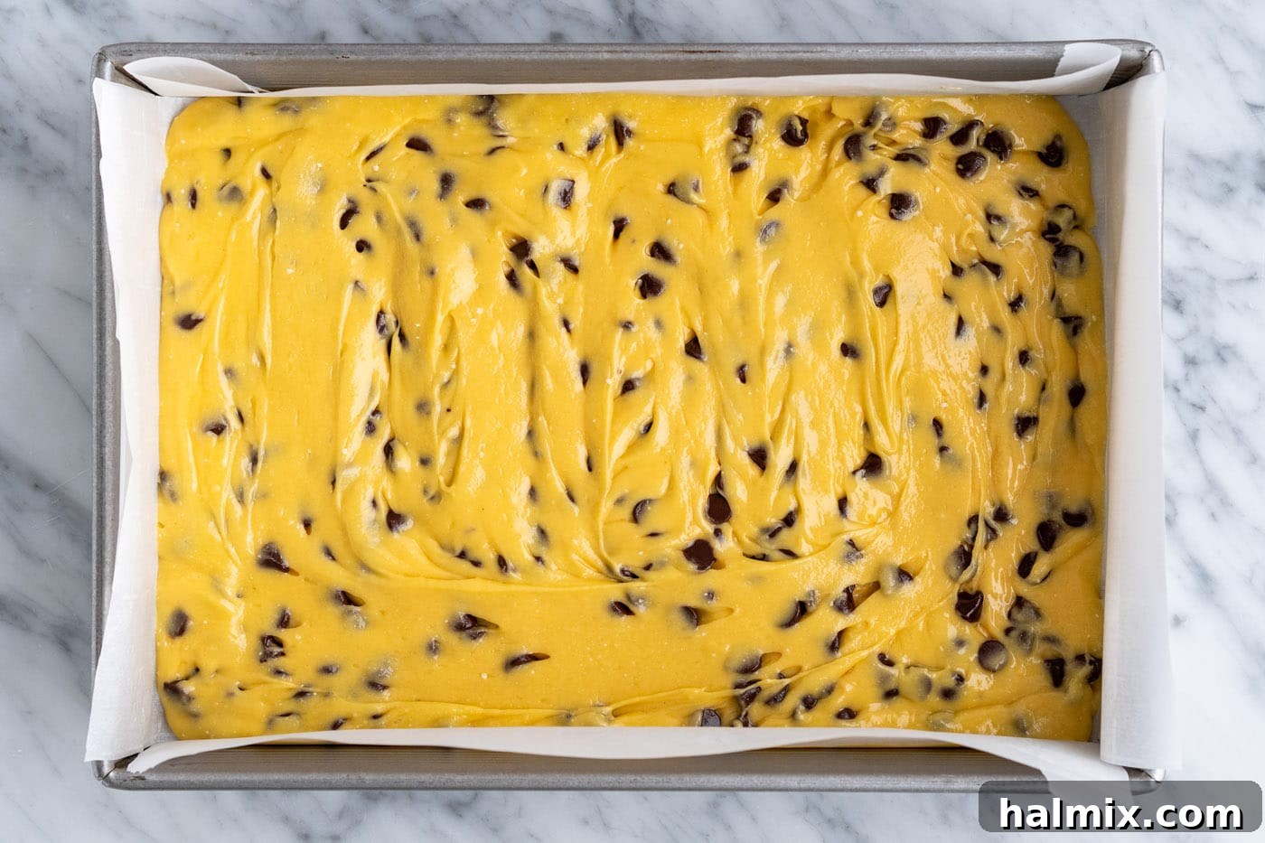 Easy Cake Mix Cookie Bars 10 Cake mix cookie bar batter smoothly spread out in the baking pan, creating an even layer.
