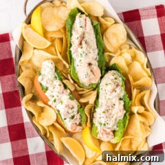 Three Shrimp Rolls in a serving tray with potato chips