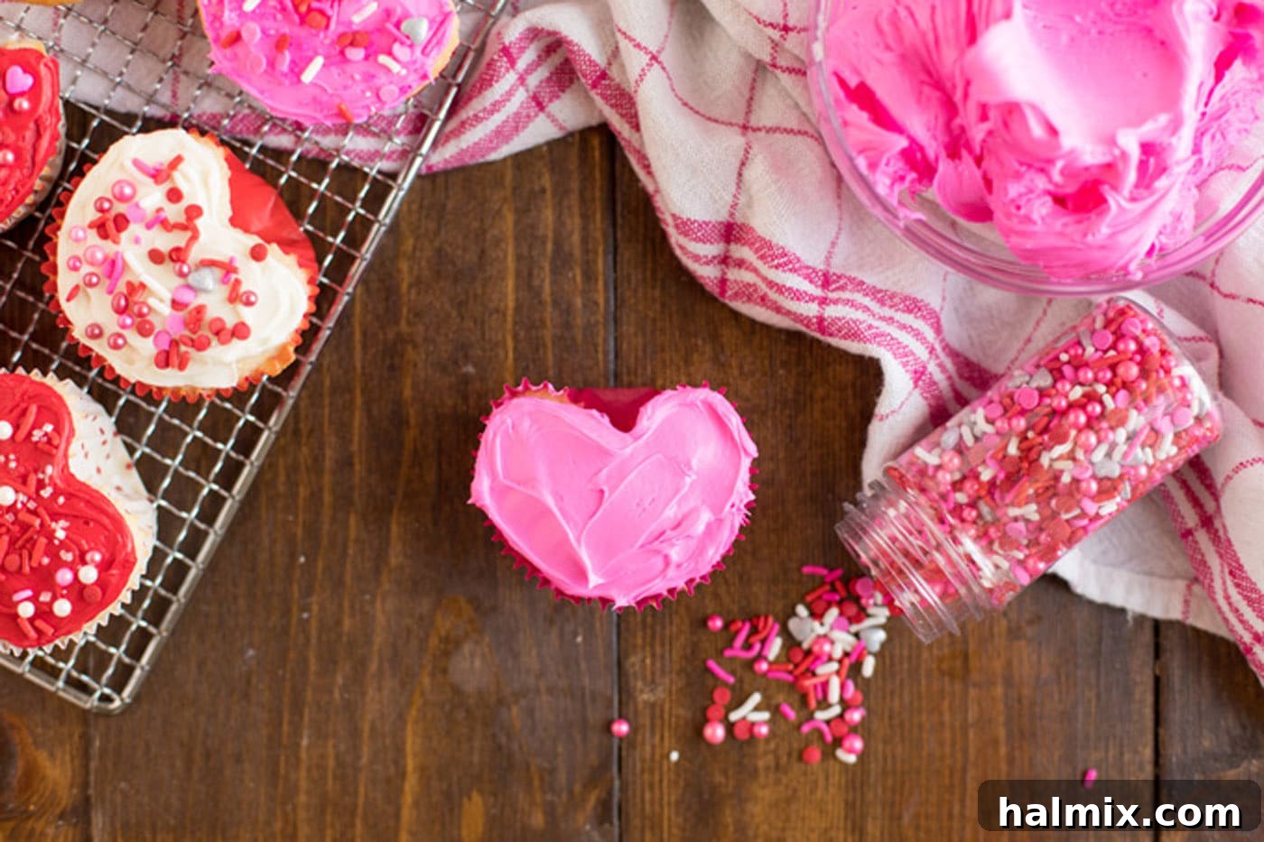 Valentine Heart Cupcake frosted with pink frosting and sprinkles on the side.
