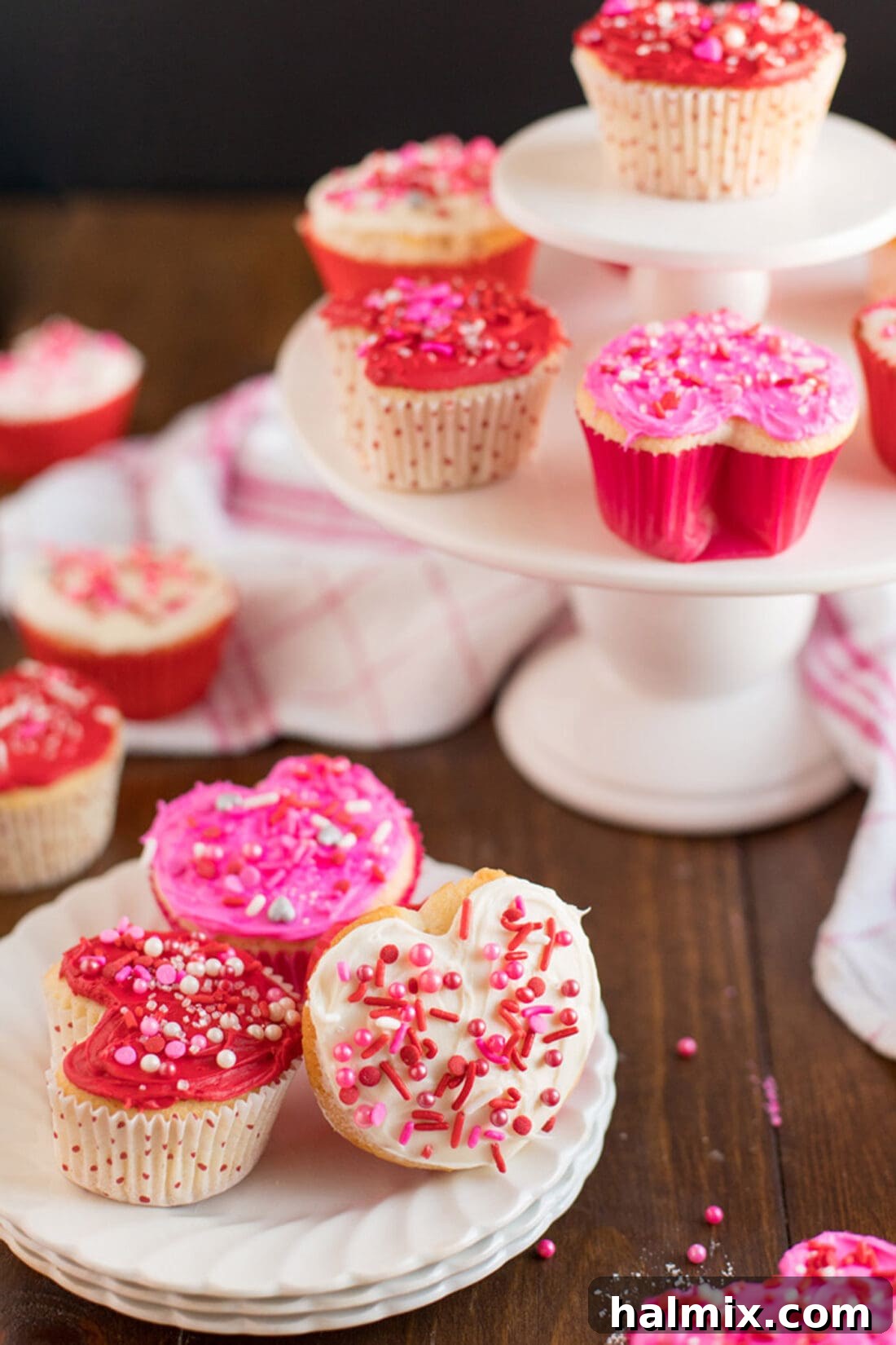 Valentine Heart Cupcakes on a plate with other cupcakes in the background, showcasing well-defined heart shapes.