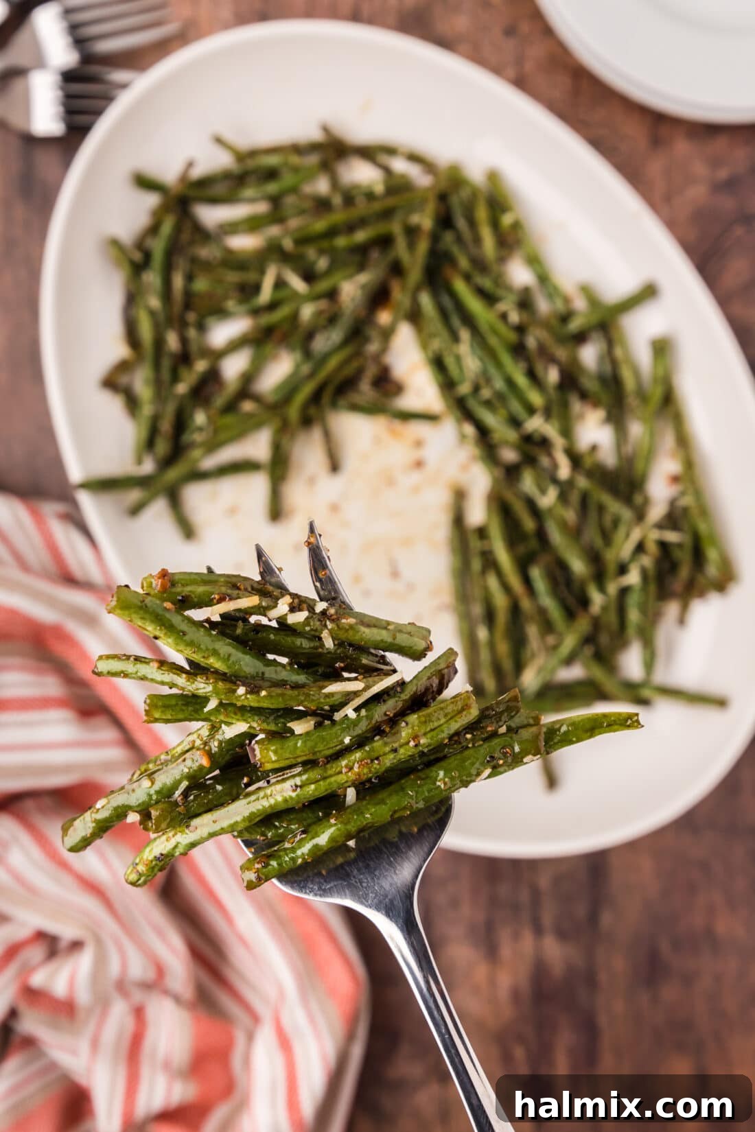 Crispy Roasted Green Beans 2 Serving fork full of Roasted Green Beans held above a platter of Roasted Green Beans