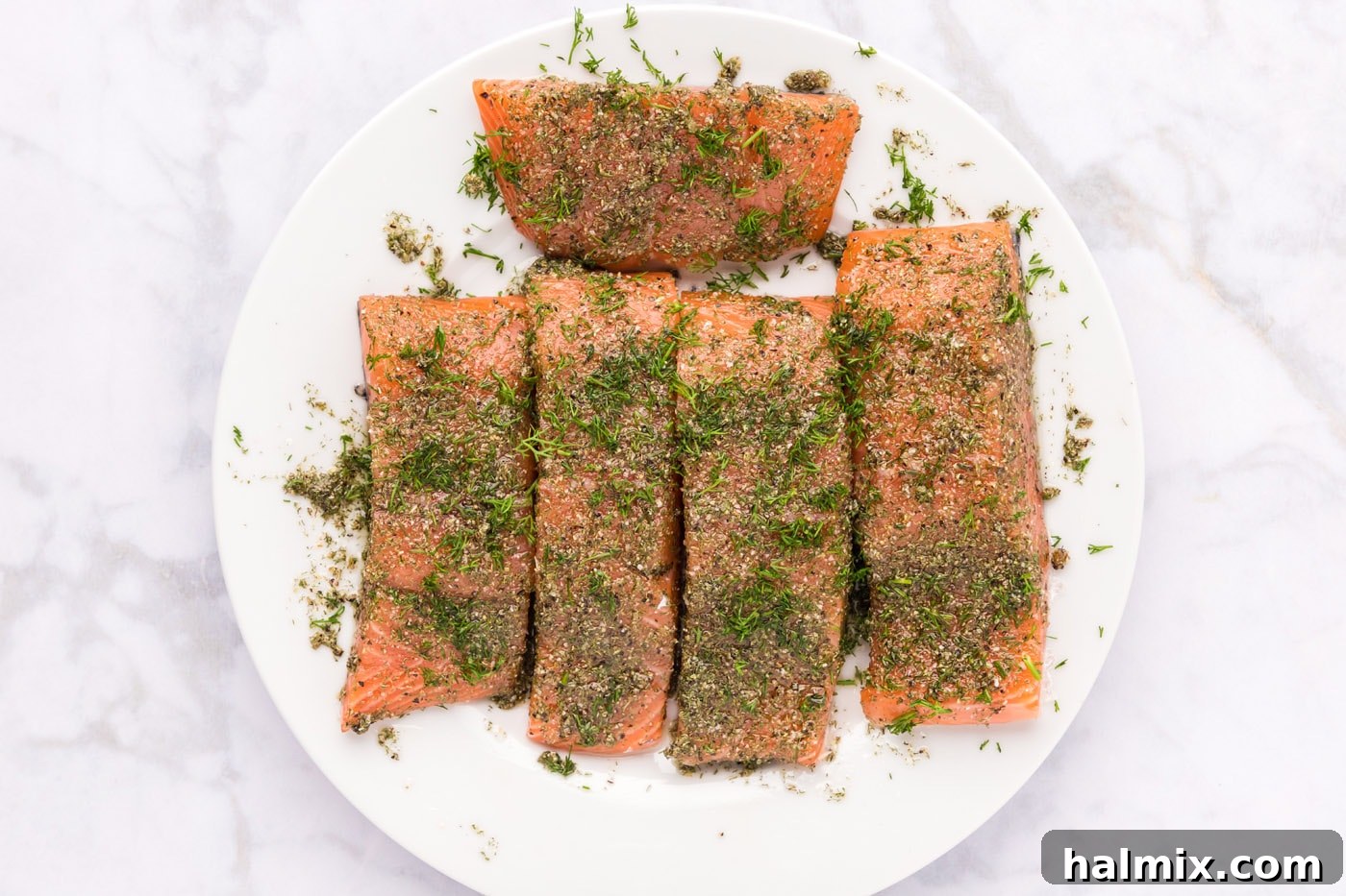 Smoked Salmon with Dill 6 Salmon fillets on a cutting board, coated generously with a dill and garlic rub, topped with fresh dill sprigs.