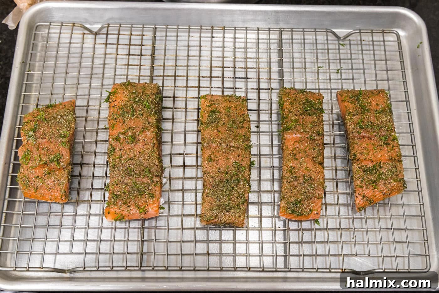 Smoked Salmon with Dill 7 Dill salmon fillets meticulously arranged on a wire rack over a baking sheet, ready for the final touches before baking.