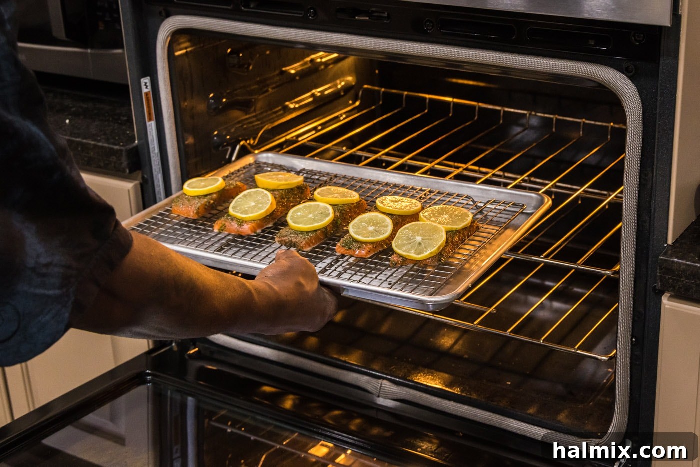 Smoked Salmon with Dill 9 A baking sheet with dill salmon and lemon slices being carefully placed into a preheated oven.