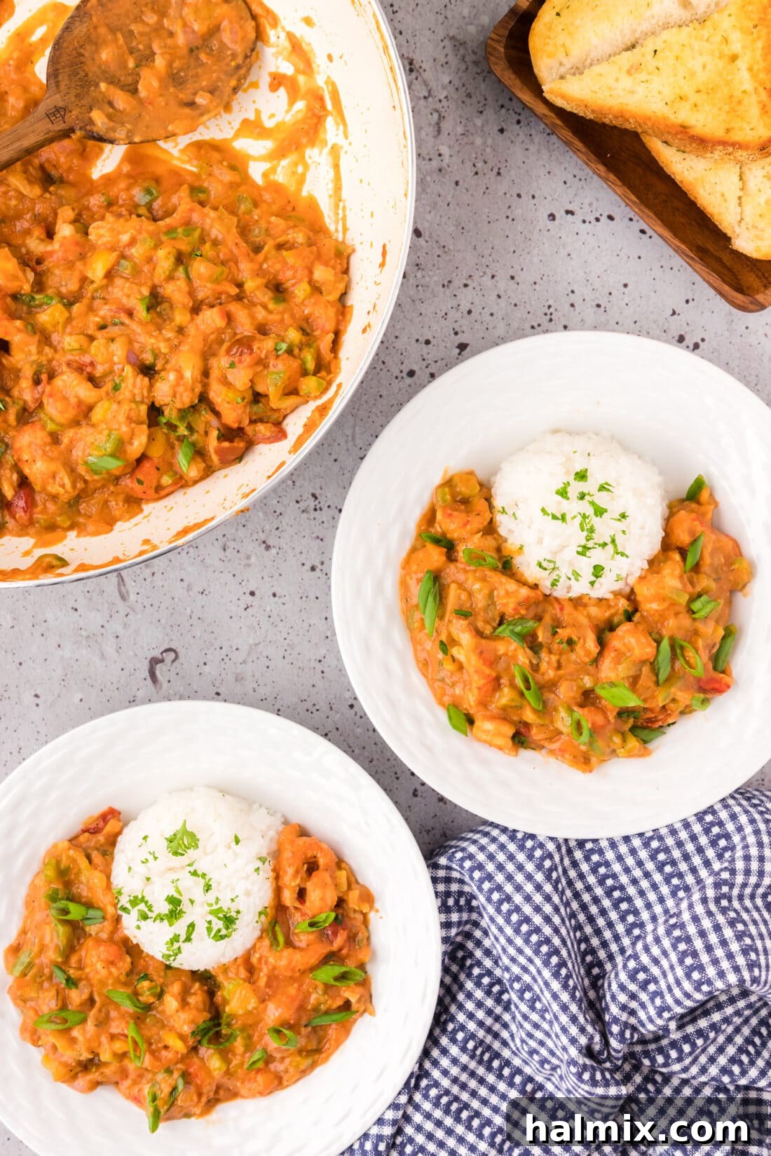 Two bowls of Crawfish Etoufee served with rice, garnished with fresh herbs