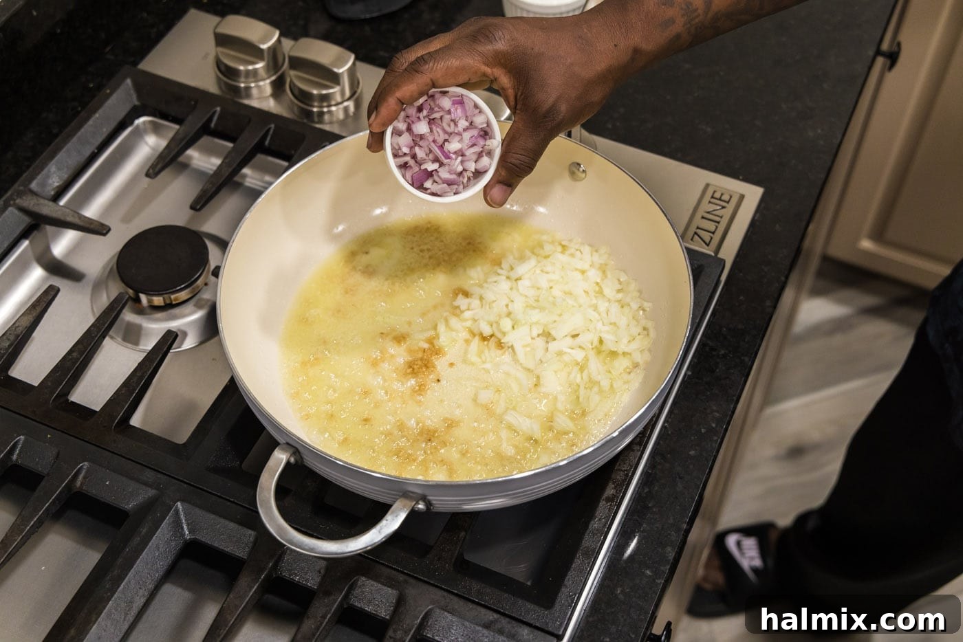 adding shallots to skillet with onion and garlic with oil