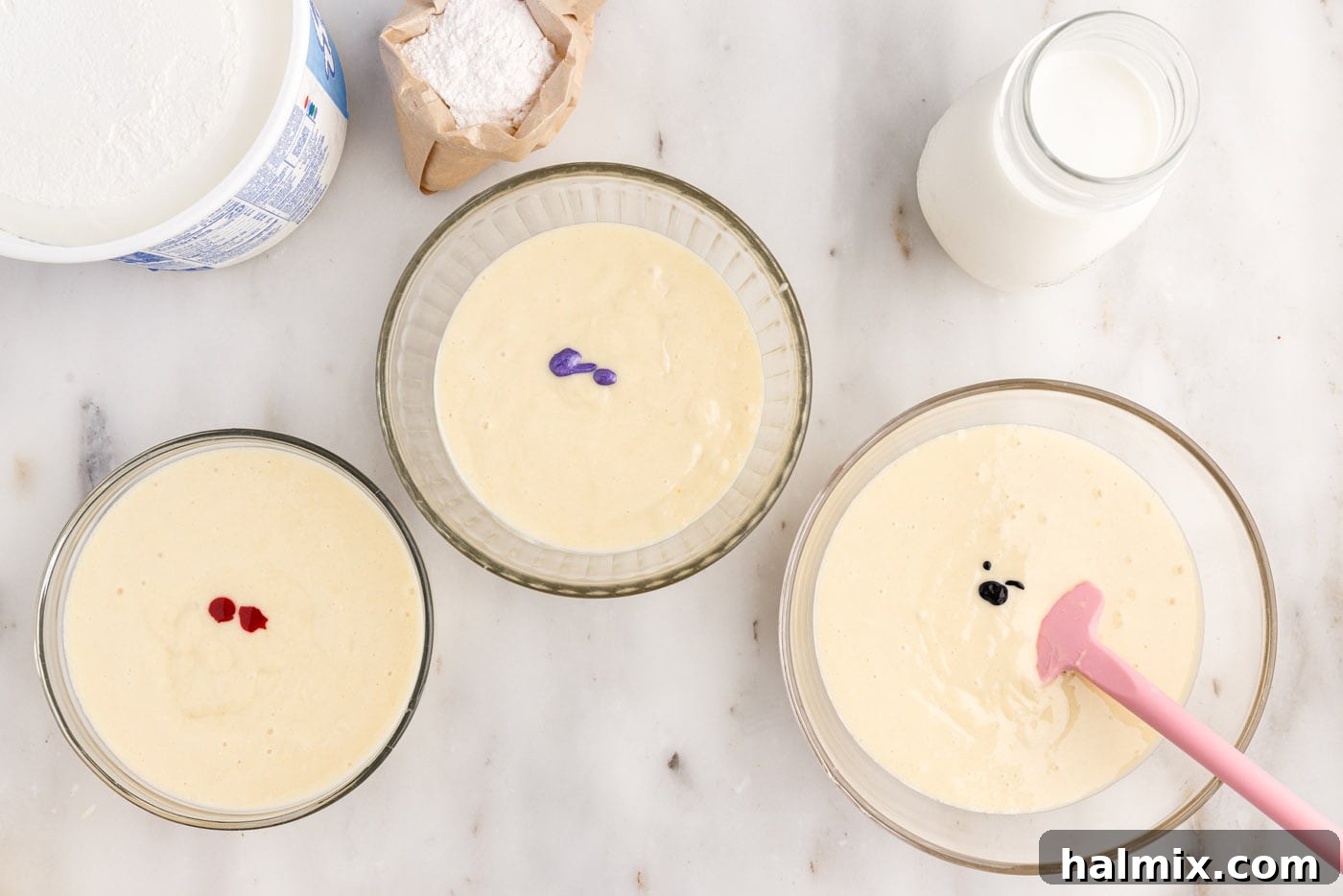 gel food coloring adding to bowls of cake batter