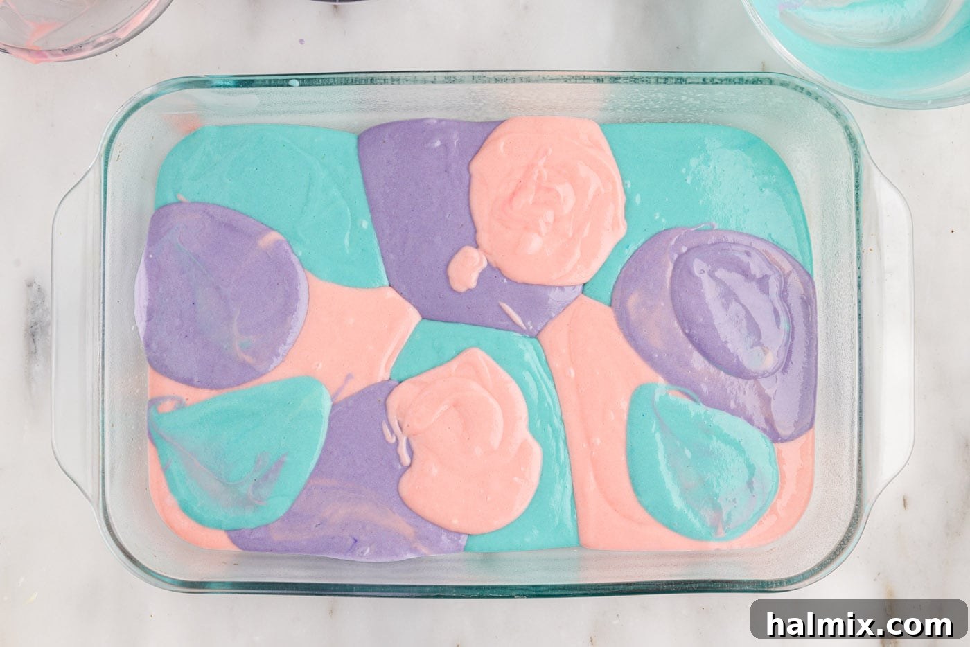 pastel colored cake batter in a baking dish