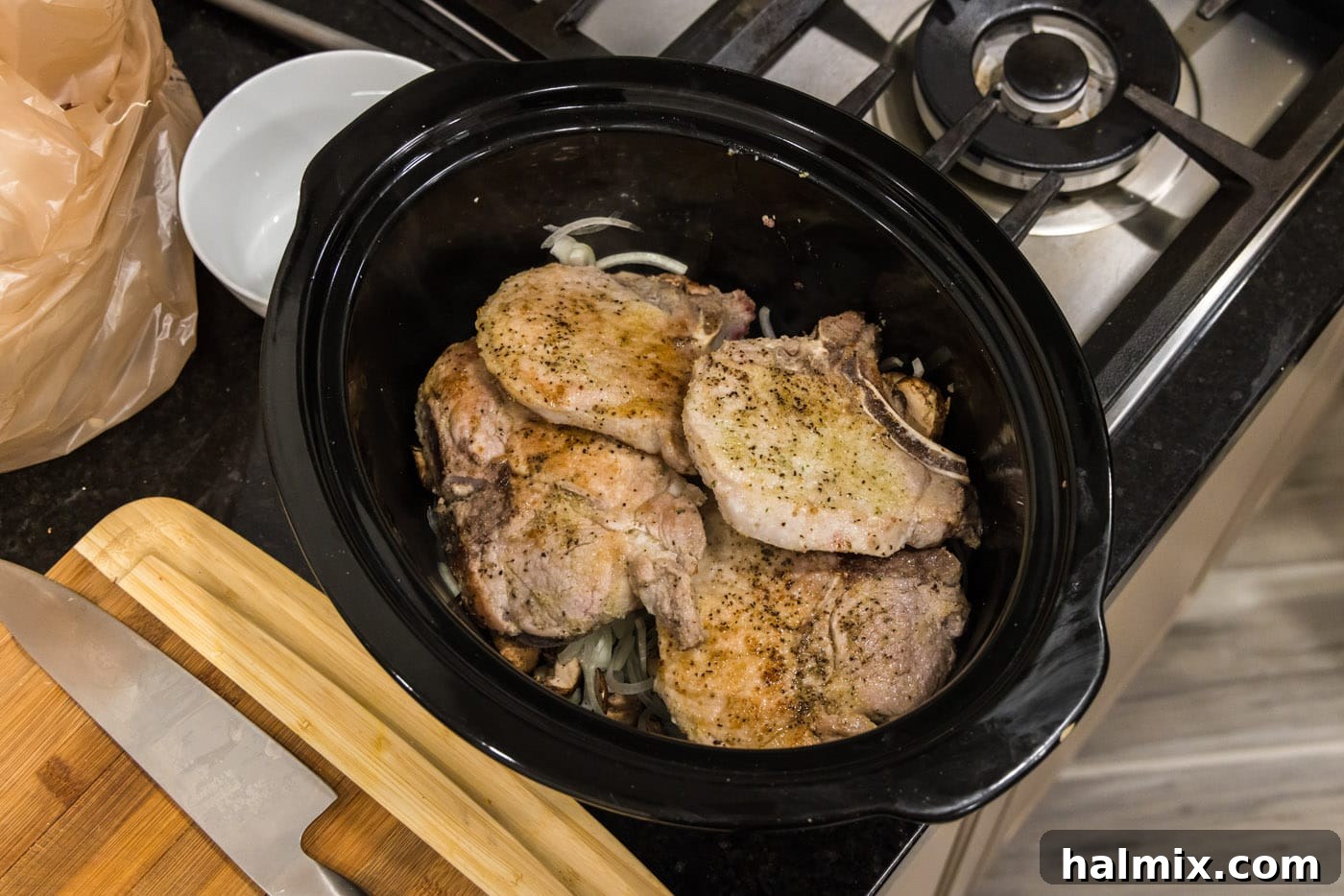 pork chop on top of onions and mushroom