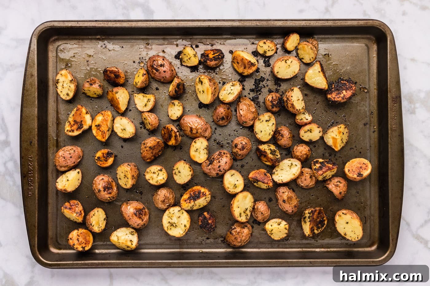 overhead shot of roasted red potatoes on a baking sheet, perfectly cooked